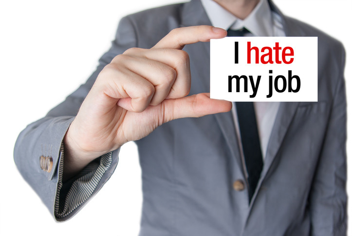 businessman holding sign that reads 'I hate my job'